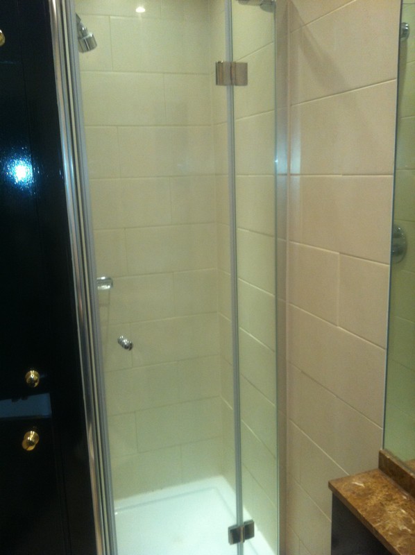 Frameless glass shower enclosure with chrome fittings in Clapton